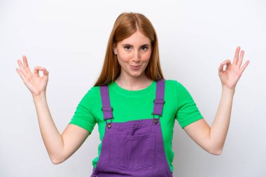 Zen pozisyonunda beyaz arka planda izole genç kızıl saçlı kadın.