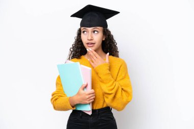 Arap üniversitesinden mezun bir kadın beyaz arka planda kitap tutuyor gülümserken yukarı bakıyor