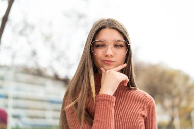 Açık havada düşünen genç bir kız.