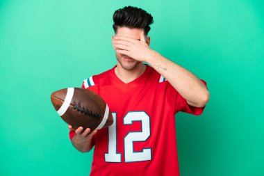 Rugby oynayan beyaz bir genç, yeşil arka planda tek başına, gözleri elleriyle kapatıyor. Bir şey görmek istemiyorum.