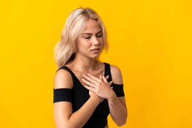 Sarı arka planda izole edilmiş genç bir Rus kadının kalbinde bir ağrı var.