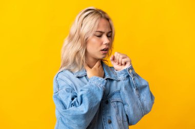 Sarı arka planda izole edilmiş genç Rus kadın çok öksürüyor.