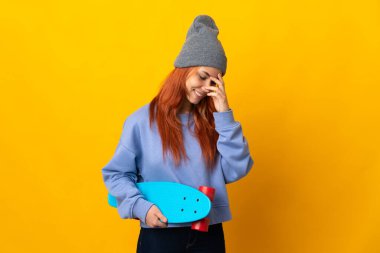 Genç Rus patenci kız sarı arka planda izole edilmiş gülüyor.