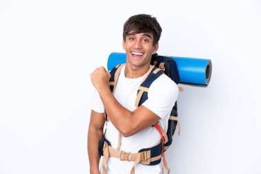 Genç dağcı kadın büyük bir sırt çantasıyla izole edilmiş beyaz arka planda zaferi kutluyor.