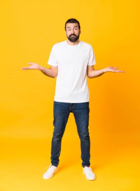 Sarı arka planda sakallı bir adamın el kaldırırken kuşkuları olduğu uzun bir fotoğraf.