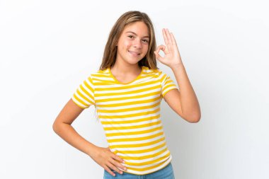 Beyaz arka planda izole edilmiş küçük beyaz kız parmaklarıyla tamam işareti gösteriyor.