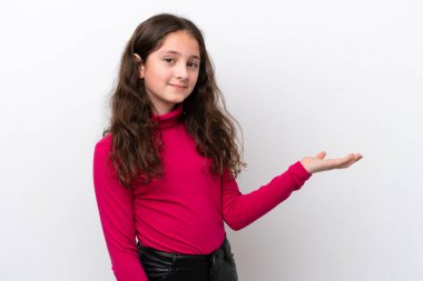 Beyaz arka planda izole edilmiş küçük bir kız bir ilan vermek için avucunun içinde hayali bir alan tutuyor.