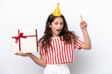 Doğum günü partisi şapkalı küçük kız beyaz arka planda, şaşırmış bir yüz ifadesiyle izole edilmiş.