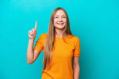 Mavi arka planda izole edilmiş genç Rus kadın harika bir fikre işaret ediyor.