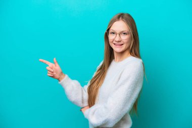 Mavi arka planda izole edilmiş genç bir Rus kadın.