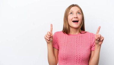 Beyaz arka planda izole edilmiş genç bir Rus kadın şaşırmış ve işaret ediyor.