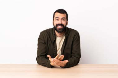 Masada sakallı beyaz bir adam gülüyor..