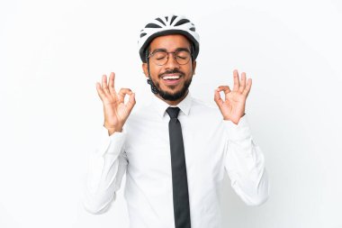 Bisiklet kaskı tutan genç iş adamı beyaz arka planda zen pozunda izole edilmiş.