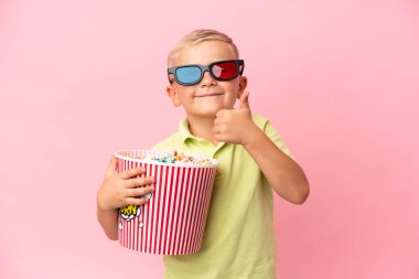 Küçük Rus çocuk izole bir arka planda büyük bir kasede patlamış mısır yiyor.