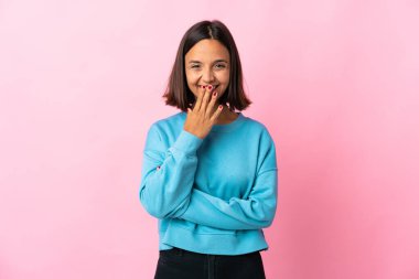 Pembe arka planda izole edilmiş genç Latin kadın mutlu ve gülümsüyor.