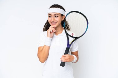 Young tennis player woman isolated on white background looking to the side and smiling