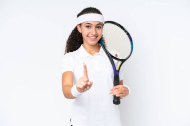 Genç tenisçi kadın beyaz arka planda izole edilmiş ve parmağını kaldırıyor.