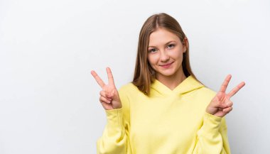 Beyaz arka planda izole edilmiş genç Rus kadın iki eliyle zafer işareti gösteriyor.