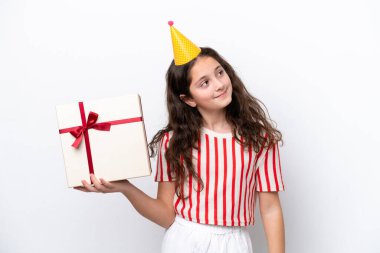 Beyaz arka planda izole edilmiş beyaz bir hediye tutan genç beyaz kadın yukarı bakarken bir fikir düşünüyor.