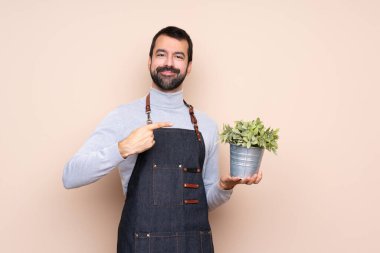 Bir bitkiyi izole edilmiş arka planda tutan adam
