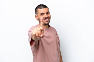 Beyaz arka planda izole edilmiş genç beyaz adam parmağını kaldırıyor ve gösteriyor.