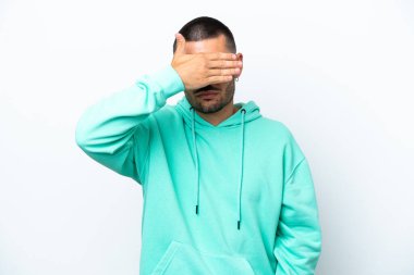 Beyaz arka planda izole edilmiş beyaz tenli genç bir adam gözlerini elleriyle kapatıyor. Bir şey görmek istemiyorum.