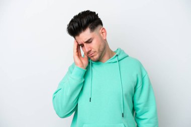 Beyaz arka planda başı ağrıyan genç beyaz bir adam.