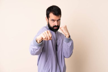 Sakallı, ceketli, münzevi bir geçmişi olan beyaz bir adam.