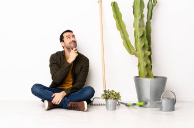 Bahçıvan içeride yerde oturuyor ve yukarı bakıyor.