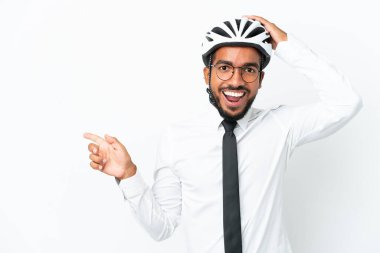 Beyaz arka planda izole edilmiş bisiklet kaskı tutan genç iş adamı şaşırdı ve parmağını yana çevirdi.