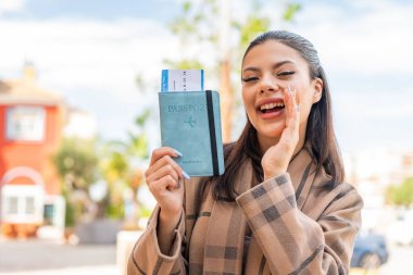 Dışarıda pasaportu olan genç ve güzel bir kadın ağzı açık bağırıyor.
