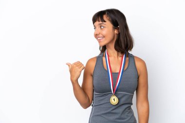 Young mixed race woman with medals isolated on white background pointing to the side to present a product