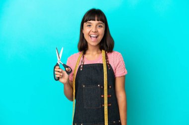 Young mixed race seasmtress woman isolated on blue background with surprise facial expression