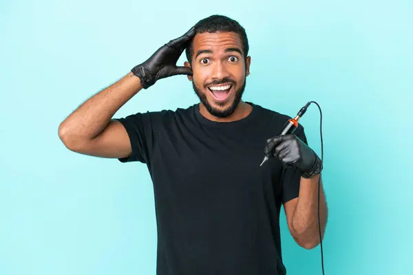 stock image Tattoo artist Ecuadorian man isolated on blue background with surprise expression