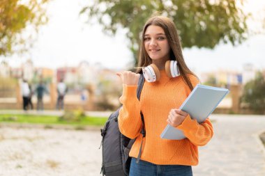 Tecrit edilmiş bir geçmişi olan genç kız bir ürünü sunmak için kenarı işaret ediyor.