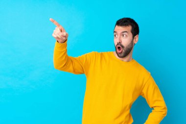 İzole edilmiş mavi arka planı olan genç beyaz bir adam...