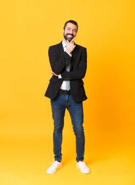 İzole edilmiş sarı arka planda gülümseyen bir iş adamı.