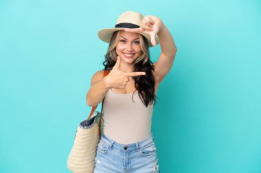 Pamel ve plaj çantalı genç Rus kız mavi arka planda izole edilmiş, odaklanan yüz. Çerçeve sembolü