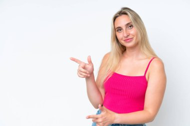 Beyaz arka planda izole edilmiş beyaz tenli genç bir kadın parmak göstererek bir ürün sunuyor.