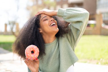Genç Afro-Amerikalı kadın elinde donut tutarken bir şeyin farkına vardı ve çözüme niyetlendi.