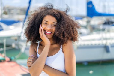 Genç Afrikalı Amerikalı kadın açık havada Neşeli bir ifadeyle