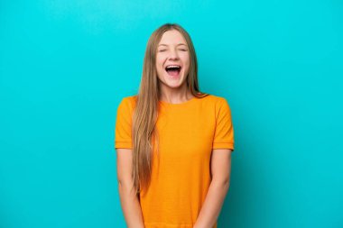Genç Rus kadın mavi arka planda izole edilmiş ve ağzı açık bağırıyor.