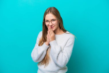 Mavi arka planda izole edilmiş genç Rus kadın avuç içlerini bir arada tutuyor. İnsan bir şey ister.