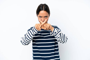 Beyaz arka planda izole edilmiş genç İspanyol kadın bir hareketi durdurmak için eliyle jest yapıyor.