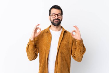 Beyaz tenli, sakallı, kadife ceket giyen beyaz tenli, Zen pozlu yakışıklı bir adam.