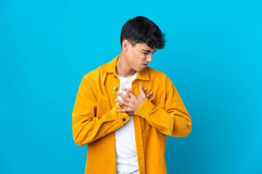 Fazla soyutlanmış mavi arka planı olan genç bir adamın kalbinde ağrı var.