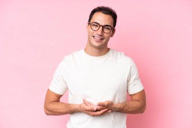 Pembe arka planda izole edilmiş genç beyaz adam gülüyor.