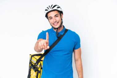 Beyaz arka planda izole edilmiş termal sırt çantalı beyaz bir adam parmağını kaldırıyor ve gösteriyor.