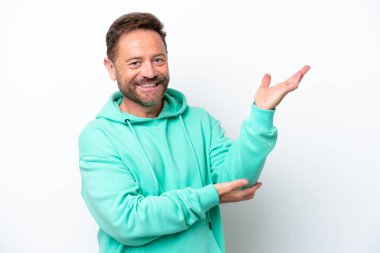 Beyaz arka planda izole edilmiş orta yaşlı beyaz bir adam davet edilmek için ellerini yana uzatıyor.