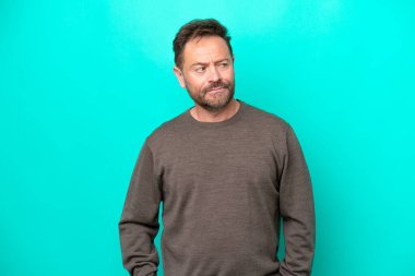 Orta yaşlı, beyaz bir adam mavi arka planda izole edilmiş.